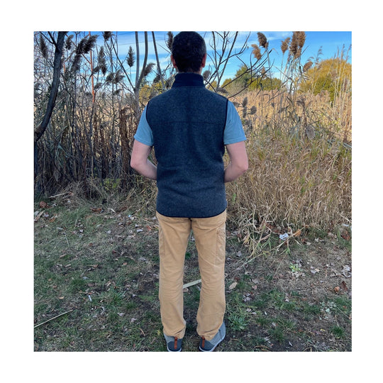 Dark blue fleece vest worn over a light blue T-shirt, shown from the back outdoors
