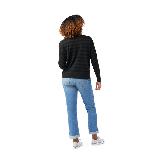 Black striped crewneck sweater shown from the back on a model wearing cuffed light blue jeans and white sneakers