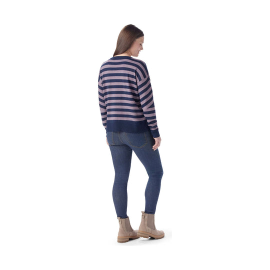Striped long-sleeve sweater worn with skinny jeans and ankle boots, shown from the back