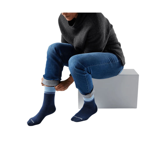 Deep navy crew socks with light blue striped cuffs on a seated model