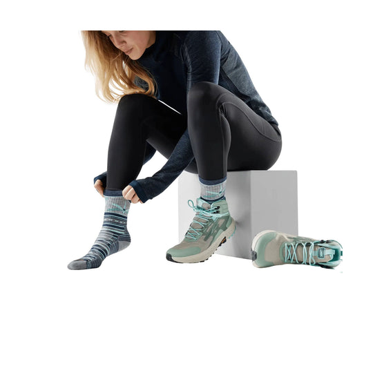 Patterned gray crew socks on a model wearing teal hiking shoes