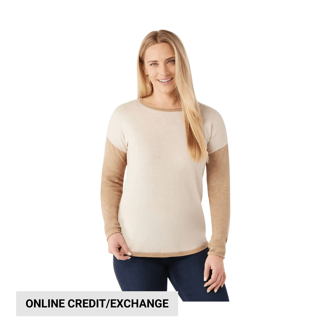 Cream and tan long-sleeve crewneck sweater with dark denim jeans