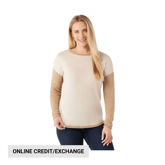 Cream and tan long-sleeve crewneck sweater with dark denim jeans