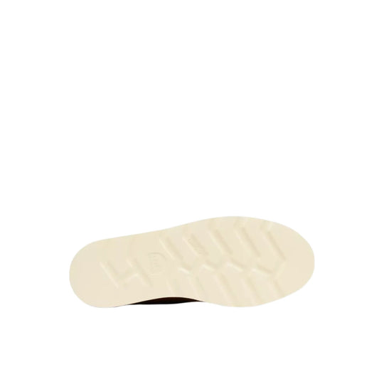 Cream lugged boot sole viewed from below with a dark brown edge at the heel