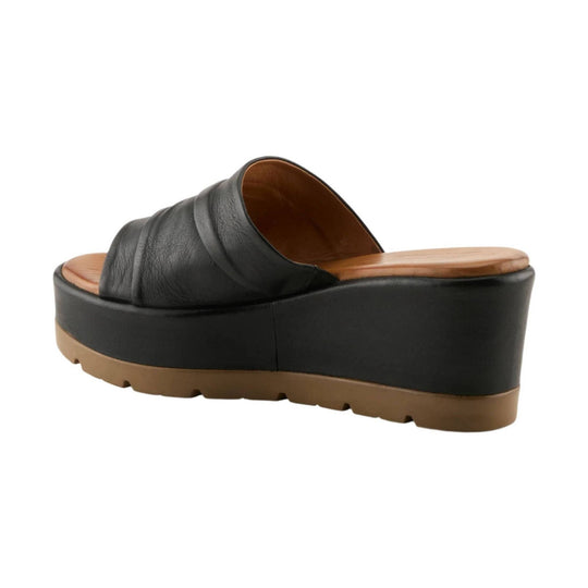 Black wedge slide sandal with tan footbed and lug sole, side view
