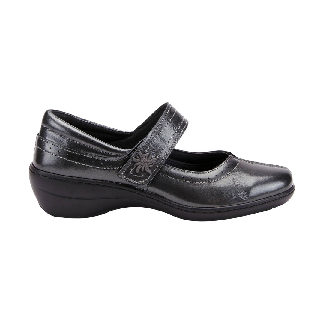 Black leather Mary Jane comfort shoe with a strap, perforated detailing, and a low wedge heel