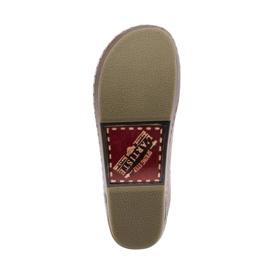 Sole of a slip-on clog with tan tread and a red logo patch