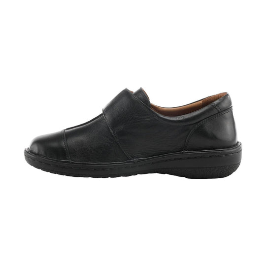 Black leather slip-on shoe with a low sole and rounded toe, side view