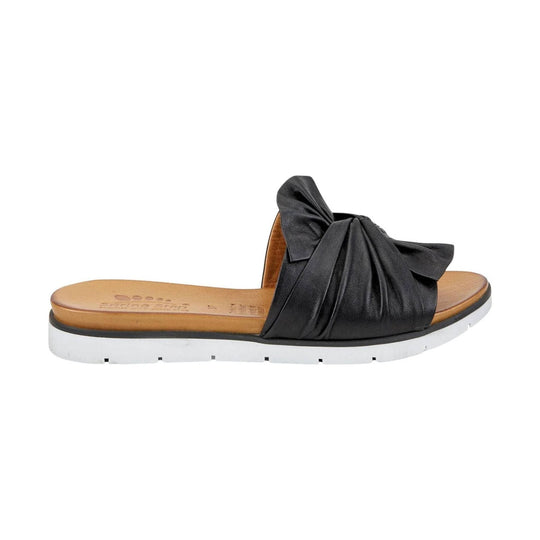 Black leather slide sandal with a large knotted bow and white lug sole