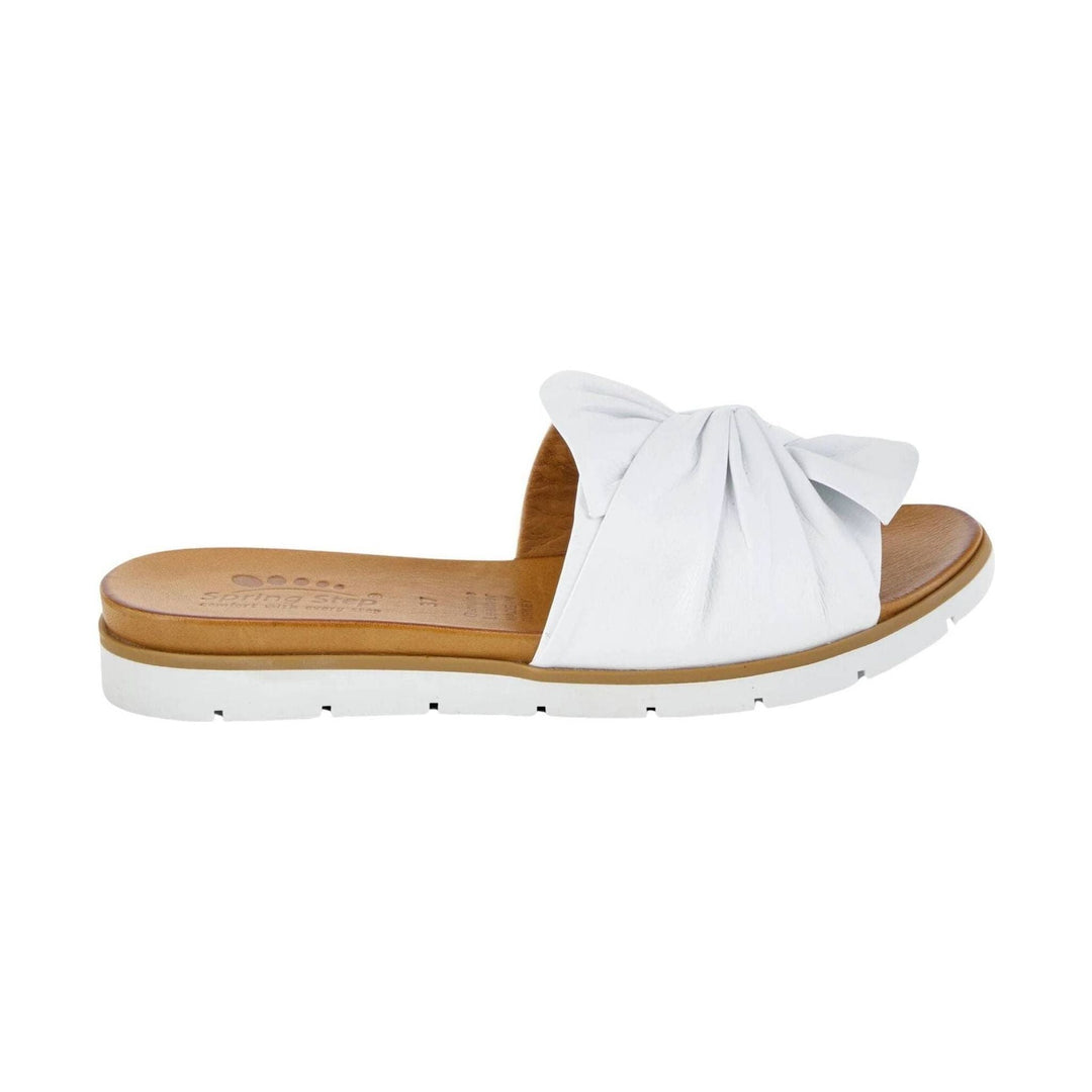 White slide sandal with a knotted wide strap, tan footbed, and white lug sole