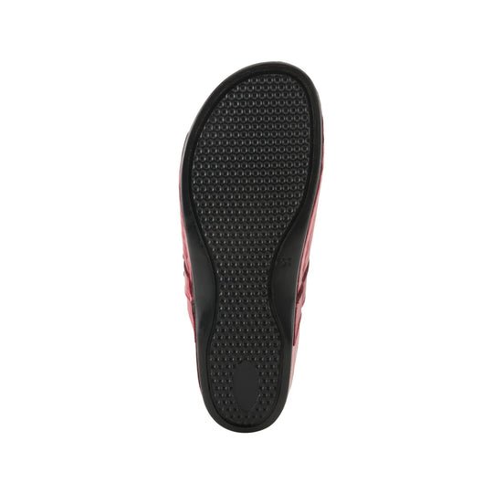Red clog shown from the bottom with a black textured outsole