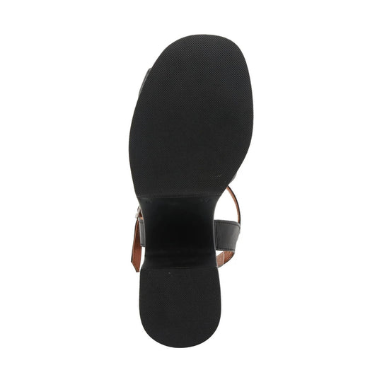 Black sandal shown from below with textured sole and ankle strap