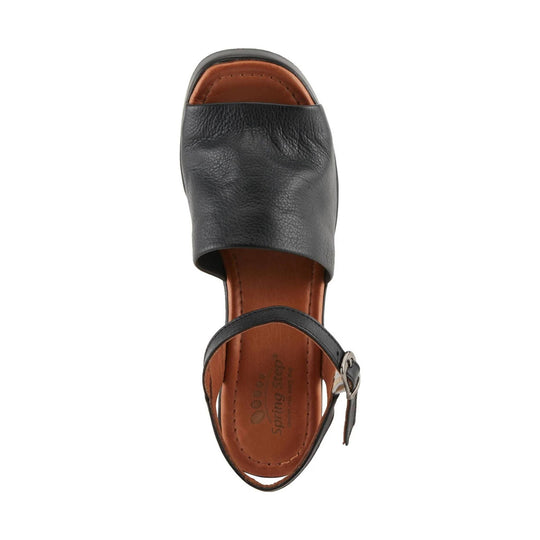 Black leather slingback sandal with an open toe, tan footbed, and adjustable ankle strap
