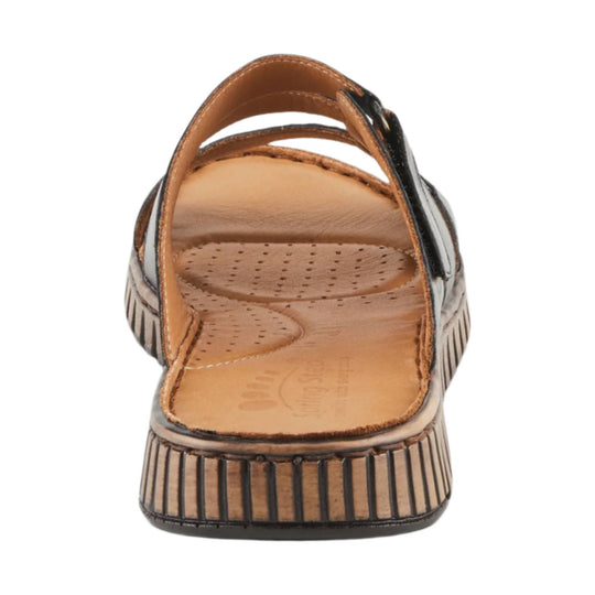 Black and tan closed-toe sandal with crisscross straps, perforated footbed, and striped wedge sole, back view