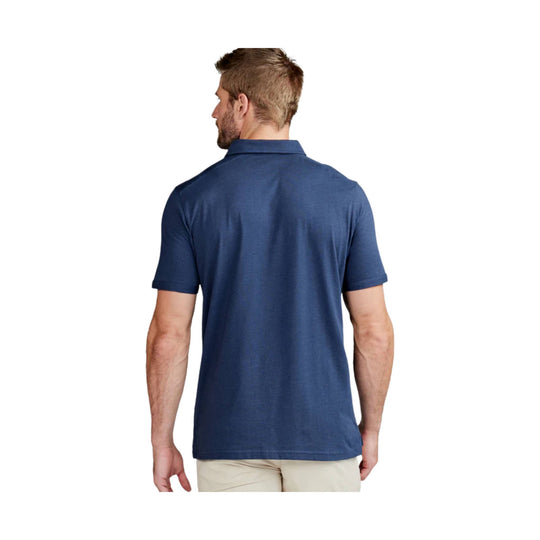 Navy short-sleeve polo shirt shown from the back on a male model