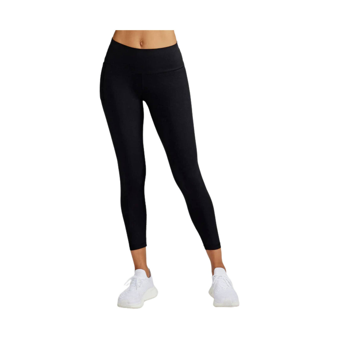 Black high-waisted 7/8 leggings with cropped hem and white sneakers