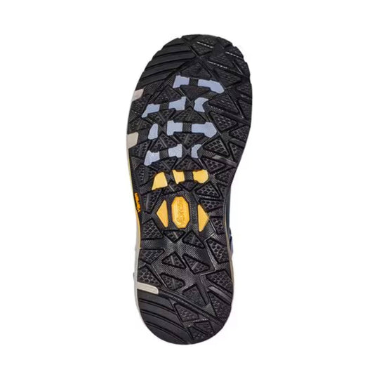 Black hiking boot outsole with triangular tread pattern and yellow midfoot inserts