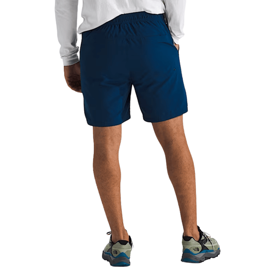 Dark blue athletic shorts worn with a white long-sleeve top, shown from the back