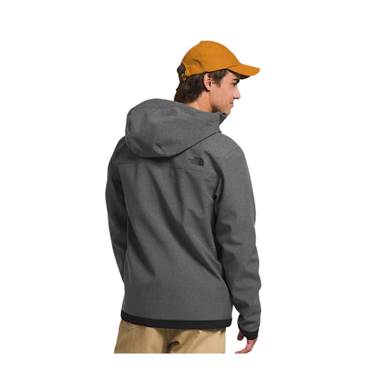 Person wearing a gray hoodie with a brand logo on the back, standing against a white background.