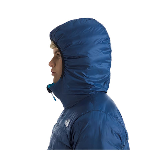 Blue hooded puffer jacket shown in side profile with a high chin guard and drawcord hood