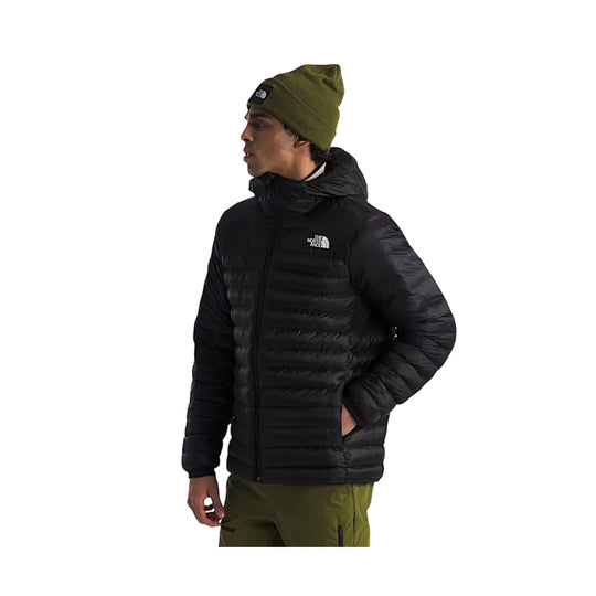 Black hooded puffer jacket worn with an olive beanie, shown in side profile.