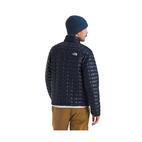 Navy quilted puffer jacket shown from the back, with a stand collar and small chest logo