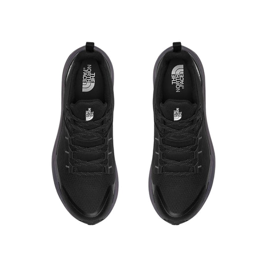 Pair of black low-top trail shoes with laces and visible logo branding on the insoles