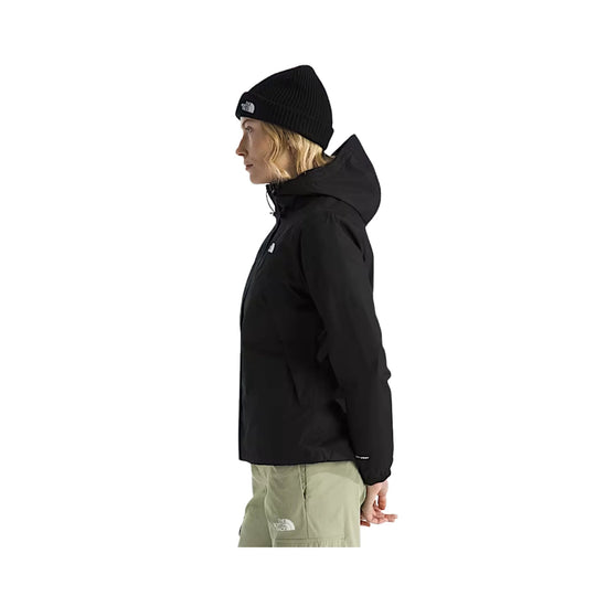Black hooded jacket worn with a black beanie and light olive pants, side view