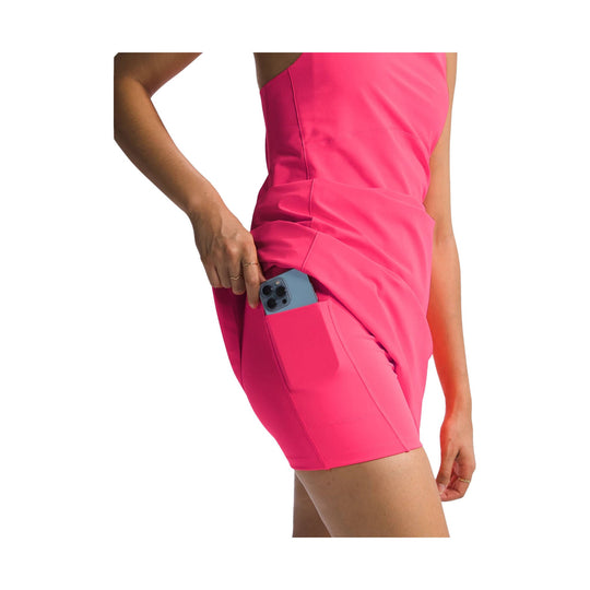 Bright pink sleeveless athletic dress with side pocket, shown on a model