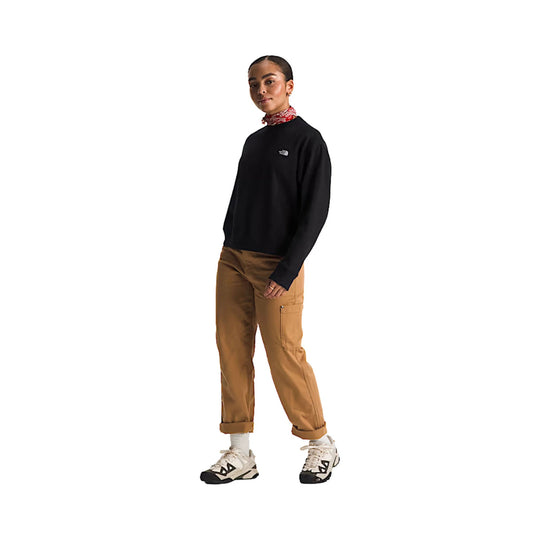 Black crewneck fleece sweatshirt with a small chest logo, worn with tan cargo pants and trail shoes