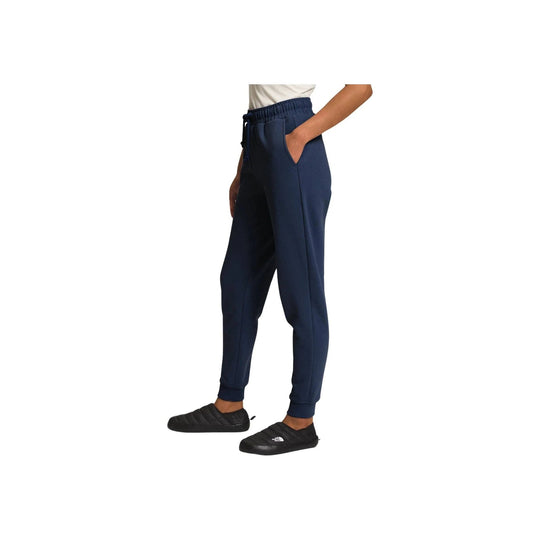 Navy tapered jogger pants with elastic waistband, side pockets, and cuffed ankles, shown on a model