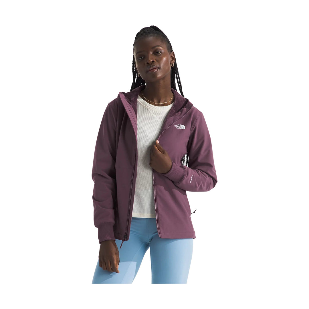 Plum zip-front hooded jacket with The North Face logo, worn over a white top and light blue leggings
