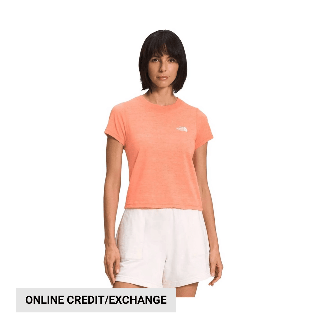 Peach short-sleeve T-shirt with small chest logo, paired with white shorts