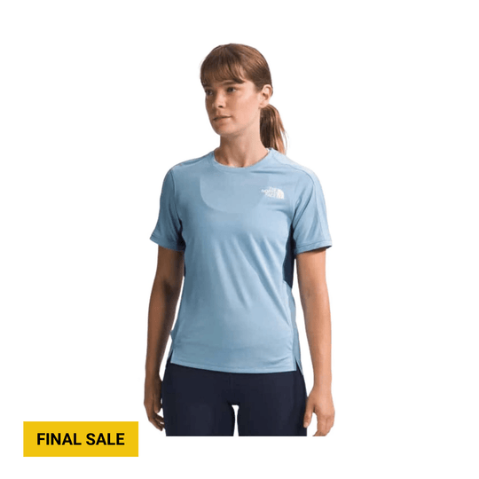 Light blue short-sleeve athletic shirt with a small logo on the chest, worn with dark leggings