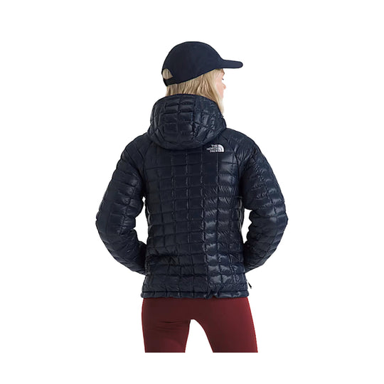 Black quilted hooded puffer jacket shown from the back on a model, with a small chest logo visible.