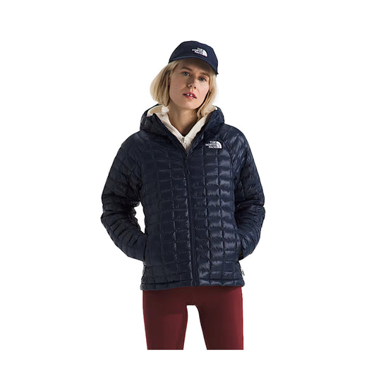 Navy quilted hooded puffer jacket worn with a white layer underneath