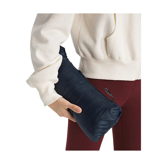 Navy packable puffer jacket folded into a compact pouch