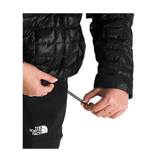 Black quilted puffer jacket with adjustable hem drawcord, shown close up on the sleeve and waist.