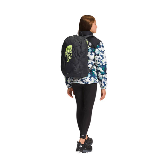 Black backpack with neon yellow The North Face logo on the back of a person