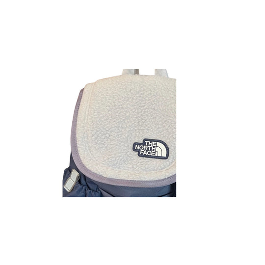 Fleece front pocket on a navy backpack with The North Face logo patch