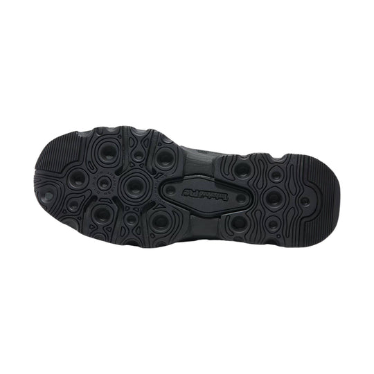 Black work shoe outsole with circular tread pods and ribbed traction sections