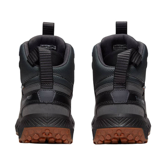 Black mid-cut work boots shown from the back with pull tabs and brown lug soles
