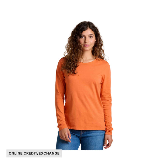 Woman wearing an orange long-sleeve crewneck shirt with blue jeans