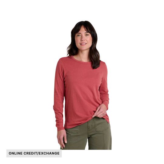 Woman wearing a coral long-sleeve crewneck top with olive pants; online credit/exchange text at bottom