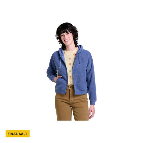 Blue zip-front hoodie with hood and drawstrings, worn over a floral top and tan pants