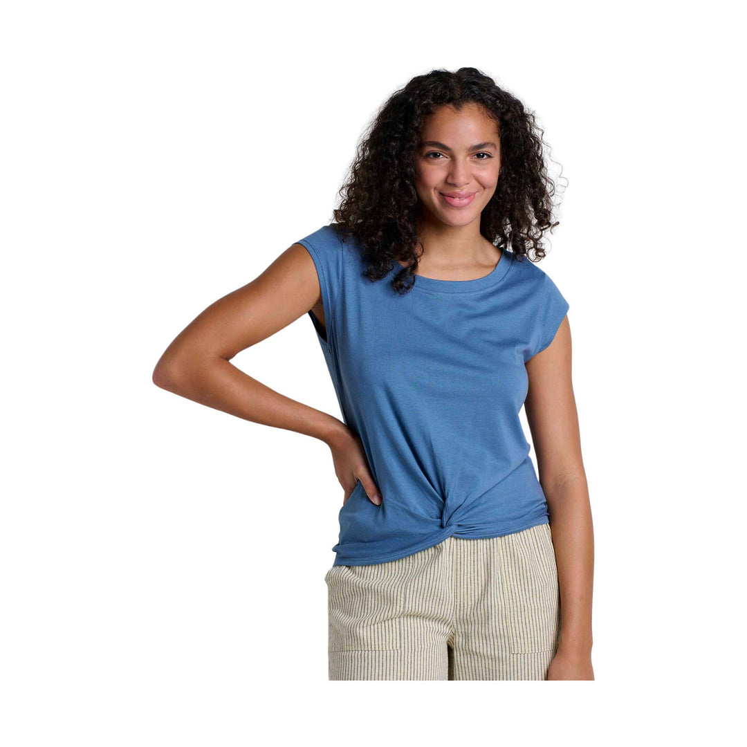 Blue sleeveless crewneck shirt with a side knot, worn with striped pants