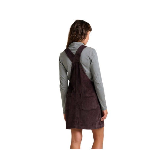 Corduroy pinafore dress with crossed back straps over a striped long-sleeve top, shown from the back