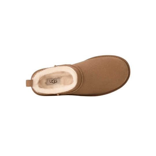 Tan suede slip-on boot with white shearling lining and UGG logo on the insole