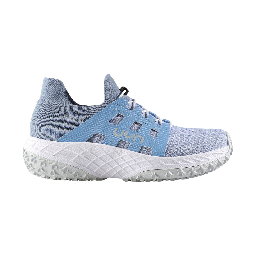 Light blue knit athletic shoe with side cutouts, white textured sole, and visible UYN logo