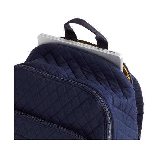 Navy quilted backpack with a laptop peeking out of the main compartment
